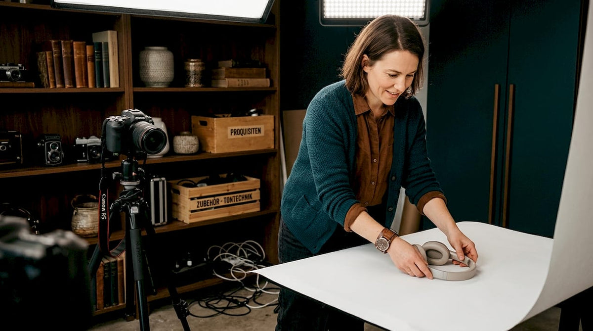Ein Fotograf richtet im Studio ein Produkt für die Aufnahme sorgfältig aus.